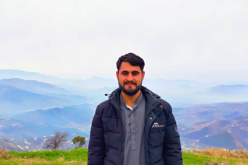 Bilal Ahmad photo with green grass and mountains in the background